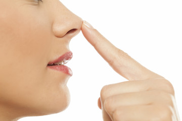 Young woman touching her nose with her finger