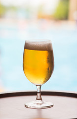 glass of craft beer with pool background