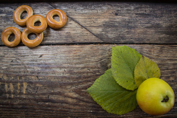 Bagels and an apple on a wooden background