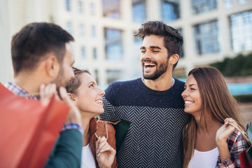 Group Of Friends Walking Along Street With Shopping Bags