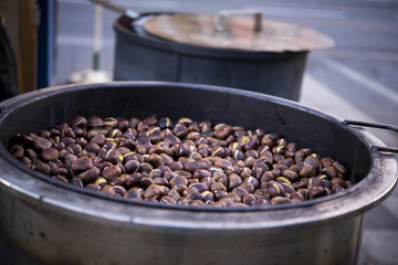 Kastanien in der Röstpfanne, dahinter zweiter Topf