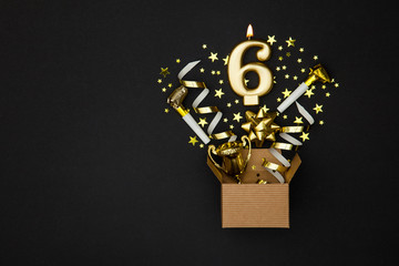 Number 6 gold celebration candle and gift box background