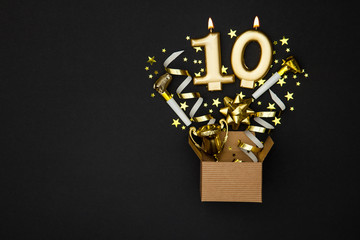 Number 10 gold celebration candle and gift box background
