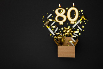 Number 80 gold celebration candle and gift box background