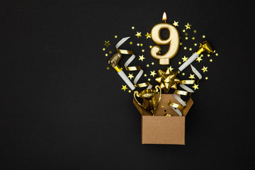 Number 9 gold celebration candle and gift box background