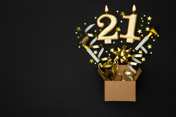 Number 21 gold celebration candle and gift box background