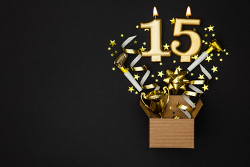 Number 15 gold celebration candle and gift box background