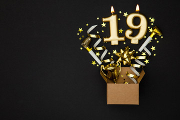 Number 19 gold celebration candle and gift box background