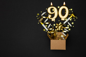 Number 90 gold celebration candle and gift box background