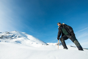 climber with an ice ax in the snowy mountains