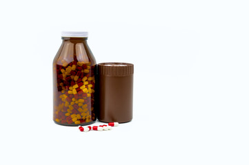 Red, white antibiotic capsules pills and two amber bottles isolated on white background with copy space and blank label. Drug resistance, antibiotic drug use with reasonable, health policy concept.