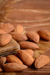 Peeled almond photo. A heap of raw almonds on a brown wooden background. Nuts kernels. Rustic style. Vertical photo