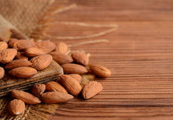 Peeled almonds. A pile of raw almonds on a wooden table. Nuts photo. Country style