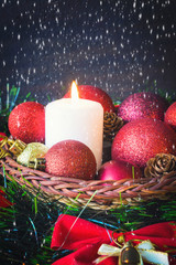 Fototapeta na wymiar Christmas red balls, candles, spruce branches, wreath and snowflakes on a dark background Decoration for a New Year's holiday with a copy space