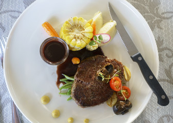 Delicious grilled Wagyu tenderloin steak with red wine sauce and vegetable on white plate