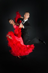 ballrom dance couple in a dance pose isolated on black background