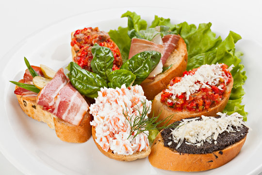 Brusketta with different fillings on the plate.