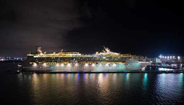 Luxury cruise ship sailing from port on sunrise.
