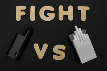 Cigarettes against Vape. Electronic cigarette over a dark background. Popular devices of year -...
