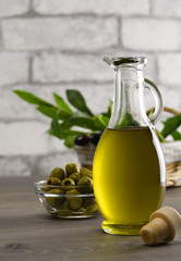 Olive oil and olive branch on the wooden table