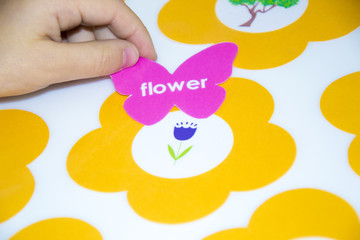 Kid is gluing a sticker on applique.