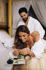 Beautiful young couple enjoying and relaxing in gorgeous hotel bedroom