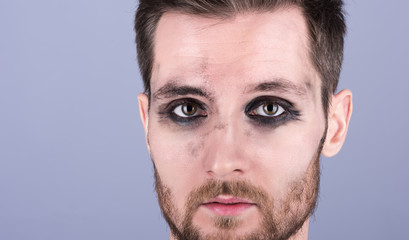Fototapeta premium Horizontal closeup portrait of a young man with dirty makeup. Beard and mustache