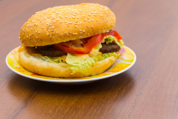 Delicious hamburger or sandwich on plate on wooden table