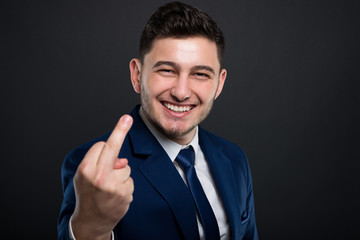 Young businessman in blue suit showing middle finger