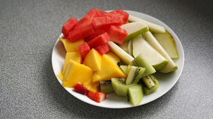 Close-up of sliced fruit salad on gray background