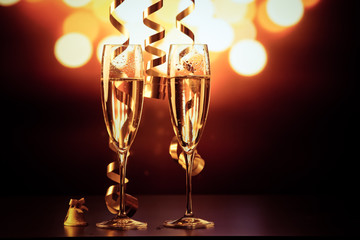 two champagne glasses with ribbons against holiday lights and fireworks - New Year celebrations