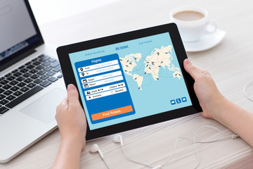 female hands holding tablet with application search air ticket screen