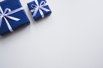Background on a white desk decorated  presents. Official background for office workers. Business template to wright words down. White bow on a box. Beautiful packaging for present.