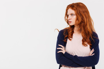 Angry pretty young redhead lady with arms crossed