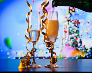 two champagne glasses with ribbons and falling confetti - New Year celebrations