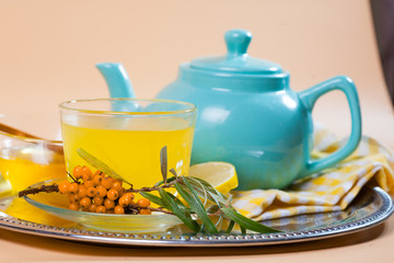 Tea made from sea buckthorn berries healthy for health delicious, saturated with vitamins surrounded by berries and sea buckthorn leaves for family tea drinking and maintaining health in the body