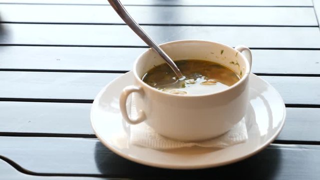 Close-up of stirring up in sour cream in borsch served in cafe or restaurant. 4k, slow motion