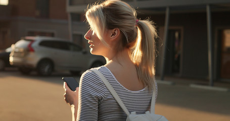 Woman with smartphone in autumn park outdoor.