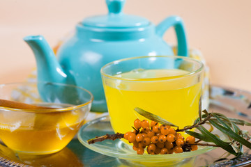 Tea made from sea buckthorn berries healthy for health delicious, saturated with vitamins surrounded by berries and sea buckthorn leaves for family tea drinking and maintaining health in the body
