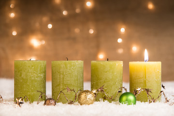 grüne adventskerzen im schnee zum 1. advent