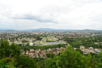 Fototapeta na wymiar Aerial view of city buildings, green summer landscape, mountains, village