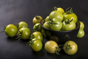 Home bred organic green tomatoes on black