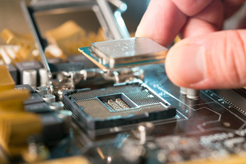 Fototapeta na wymiar Technician plug in CPU microprocessor to motherboard socket