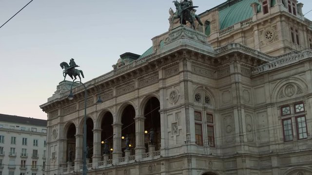 Slow tilt down the facade of the Vienna Opera House early evening in September as the city lights are coming on. Taken from Opernring