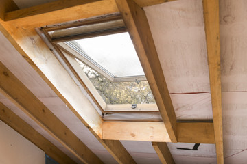 Wooden mansard or skylight window on attic. Attic renovation and insulation