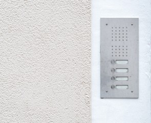 Alte Haustürklingel mit Gegensprechanlage an einer Hauswand 