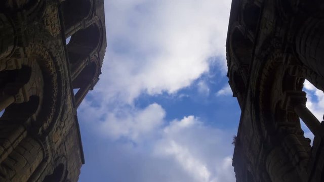 The arch windows of the ruins of Jedburgh Abbey in Scotland and clouds.