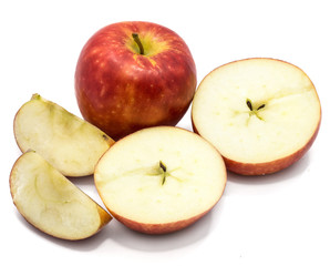 One whole Kanzi apple, two cross section halves and slices, isolated on white backgound
