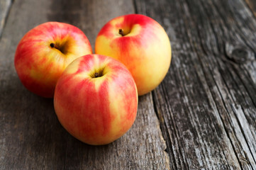 Three apples on wooden background