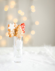 Christmas ginger cookies in the form of a Christmas tree and stars on a bright background with Christmas lights. Original Christmas card. Place for your text and congratulations